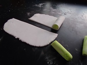 Roll out a thin piece of white fondant to cover each of the green sticks. this becomes the pith between each segment.