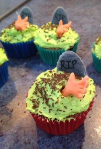 ...and graveyard cupcakes. The hands and tombstones are made from fondant. The "dirt" is chocolate sprinkles.